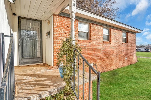 entrance to property with a lawn