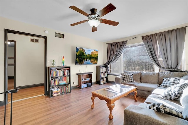 living room featuring ceiling fan and hardwood / wood-style floors