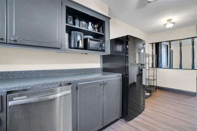 kitchen with stainless steel dishwasher, light hardwood / wood-style floors, black fridge, and gray cabinetry