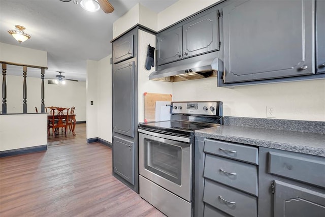 kitchen with electric range, dark hardwood / wood-style floors, gray cabinets, and ceiling fan