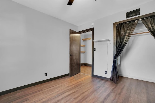 unfurnished bedroom featuring ceiling fan, a closet, and wood-type flooring