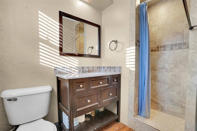 bathroom with wood-type flooring, vanity, toilet, and curtained shower