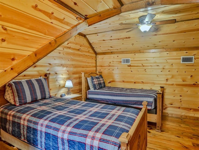 bedroom with ceiling fan, wooden ceiling, hardwood / wood-style floors, lofted ceiling, and wooden walls