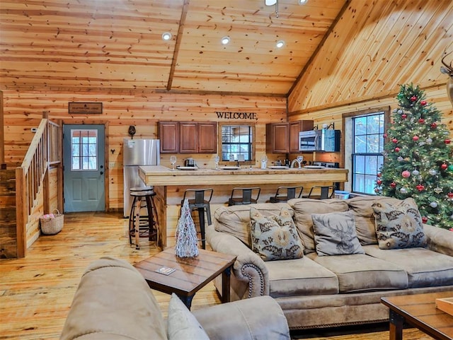 527 High Peak Trl, Broken Bow, OK 74728 - living room with lofted ceiling, wooden walls, wooden ceiling, stairway, and light wood finished floors