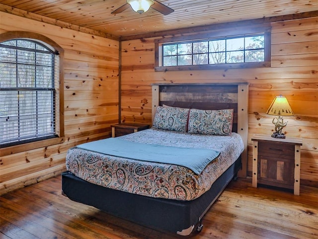 527 High Peak Trl, Broken Bow, OK 74728 - bedroom with multiple windows, wood ceiling, hardwood / wood-style floors, wood walls, and a ceiling fan