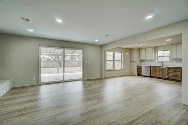 unfurnished living room with sink and light hardwood / wood-style flooring