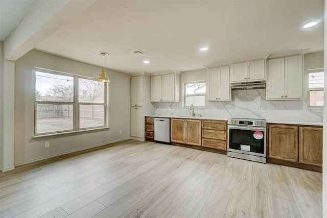 kitchen featuring tasteful backsplash, stainless steel appliances, light hardwood / wood-style flooring, and hanging light fixtures