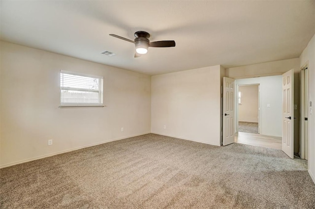 empty room featuring ceiling fan and light carpet