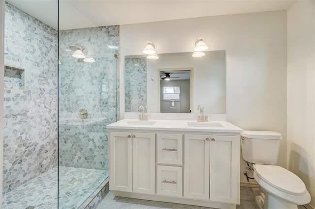 bathroom featuring tiled shower, vanity, toilet, and ceiling fan