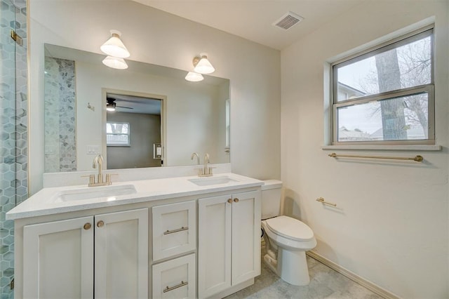 bathroom with vanity, toilet, ceiling fan, and a healthy amount of sunlight