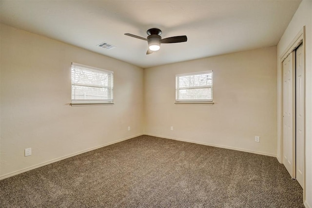 unfurnished bedroom featuring ceiling fan and dark carpet