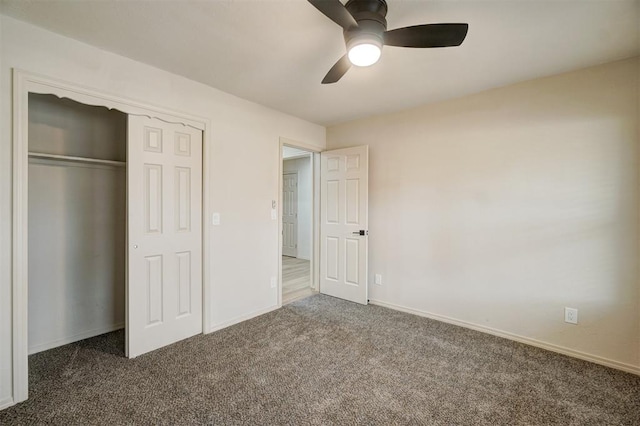 unfurnished bedroom with dark colored carpet, a closet, and ceiling fan