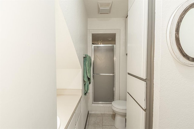 bathroom with tile patterned floors, vanity, toilet, and an enclosed shower