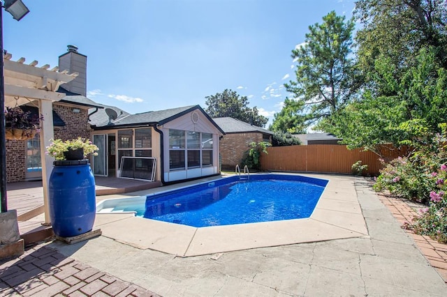 view of pool with a pergola, a sunroom, and a patio