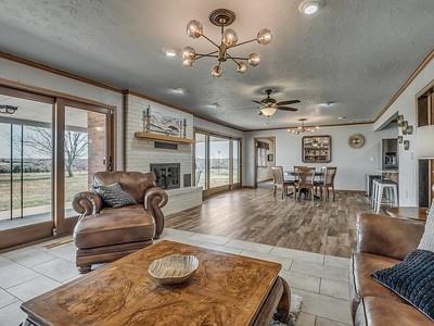 living room featuring a wealth of natural light, a fireplace, ceiling fan with notable chandelier, and light wood-type flooring