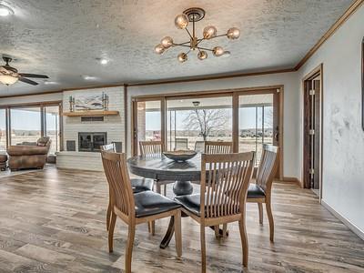 dining space with a textured ceiling, hardwood / wood-style flooring, a fireplace, ceiling fan with notable chandelier, and ornamental molding