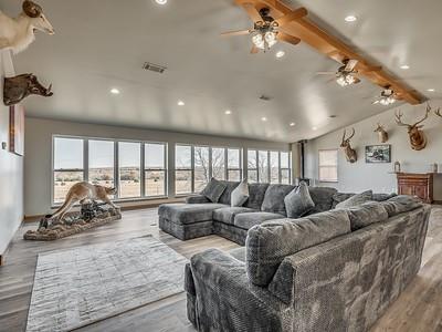 living room featuring hardwood / wood-style flooring, ceiling fan, beam ceiling, and high vaulted ceiling