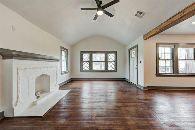 unfurnished living room with vaulted ceiling with beams, a wealth of natural light, dark hardwood / wood-style flooring, and a brick fireplace