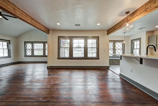 unfurnished living room featuring vaulted ceiling with beams, dark hardwood / wood-style flooring, and ceiling fan