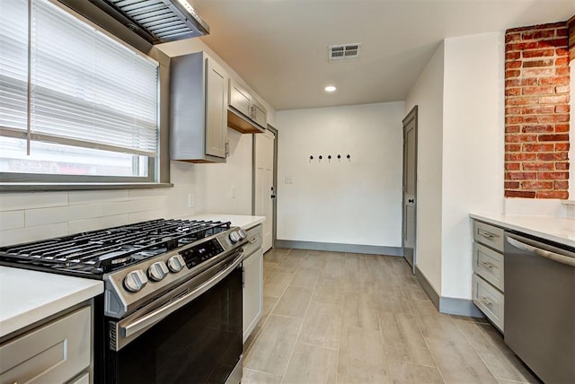 kitchen featuring light wood-type flooring, stainless steel appliances, and gray cabinetry