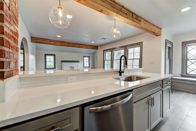 kitchen with beam ceiling, gray cabinets, sink, and stainless steel dishwasher