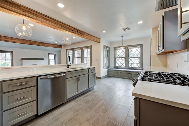 kitchen with sink, stainless steel appliances, beamed ceiling, pendant lighting, and gray cabinets