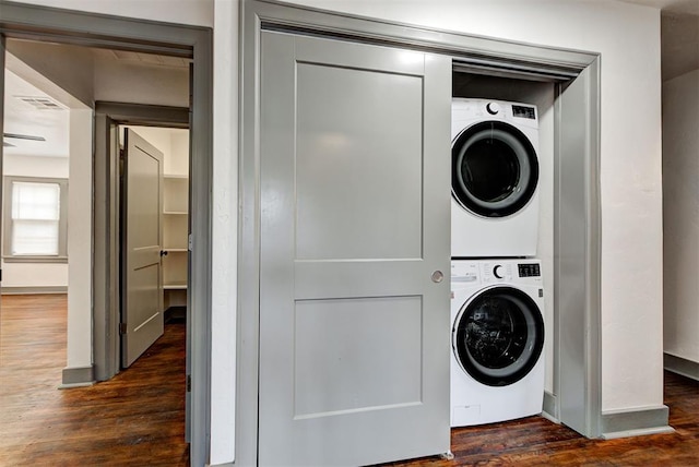 washroom with dark hardwood / wood-style flooring and stacked washing maching and dryer