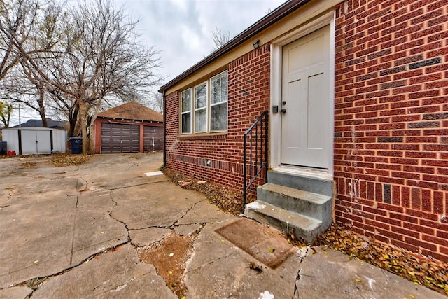 doorway to property with a garage and brick siding