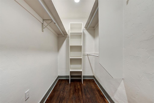 walk in closet with dark wood-style flooring