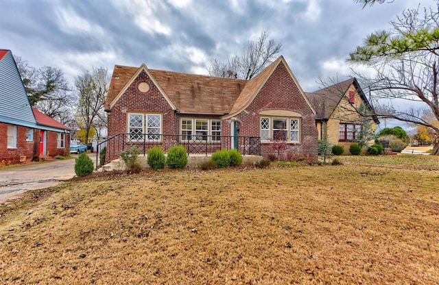 tudor-style house with a front yard and brick siding