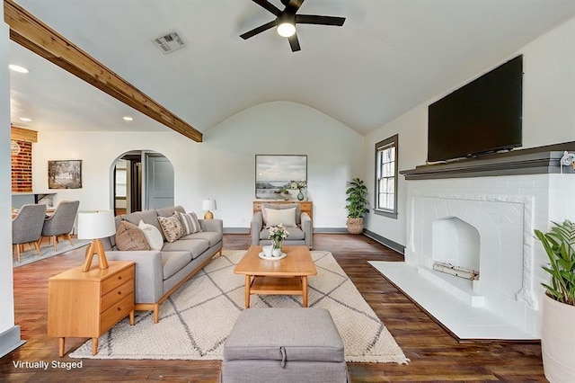 living room with baseboards, visible vents, arched walkways, lofted ceiling with beams, and wood finished floors