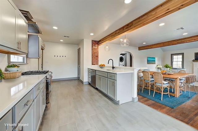 kitchen with visible vents, light countertops, appliances with stainless steel finishes, gray cabinets, and decorative light fixtures