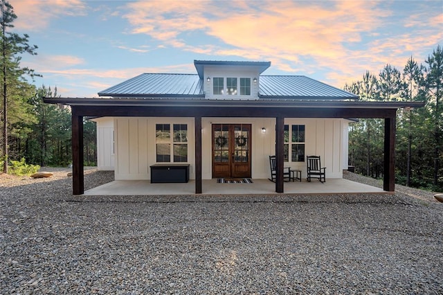 back house at dusk featuring a patio