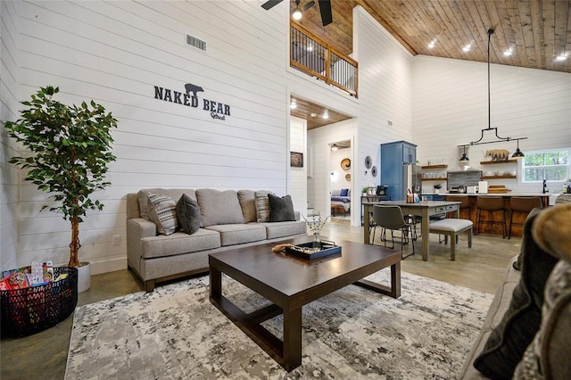 living room featuring concrete floors, high vaulted ceiling, ceiling fan, and wooden ceiling