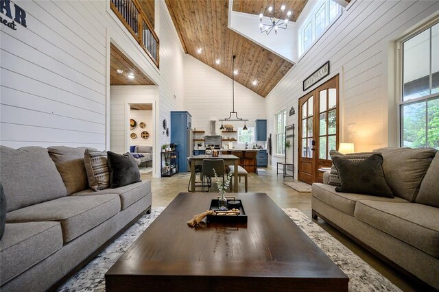 living room with a chandelier, plenty of natural light, high vaulted ceiling, and wood ceiling