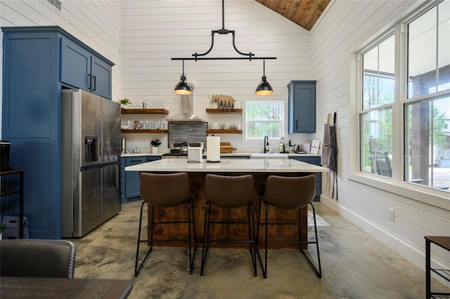 kitchen featuring a healthy amount of sunlight, blue cabinets, and stainless steel appliances