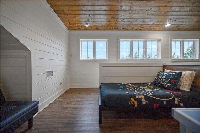 bedroom with multiple windows, wooden walls, wood ceiling, and dark hardwood / wood-style floors