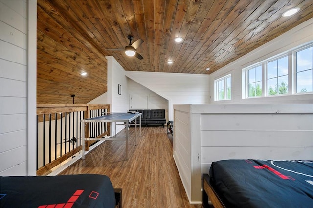 bedroom with wooden walls, wood ceiling, vaulted ceiling, and wood-type flooring