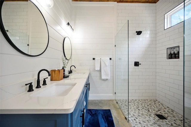 bathroom with tile patterned floors, vanity, and a tile shower