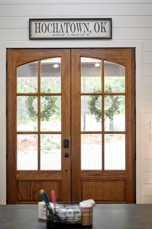 entryway with wood walls and french doors