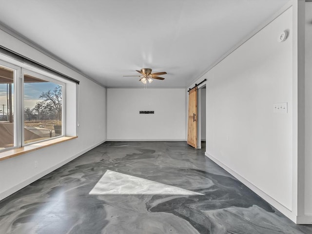 empty room with ceiling fan and a barn door