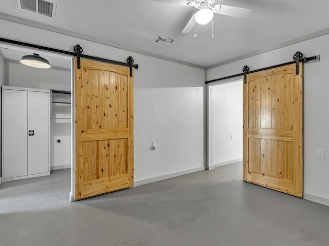 unfurnished bedroom with a barn door, a closet, ceiling fan, and concrete floors