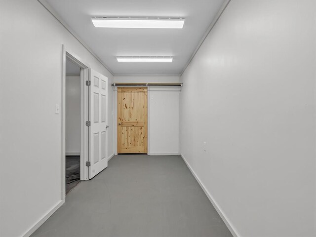 corridor with concrete flooring and a barn door