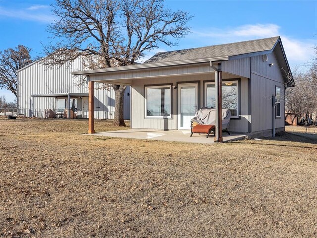 back of property featuring a patio area and a lawn