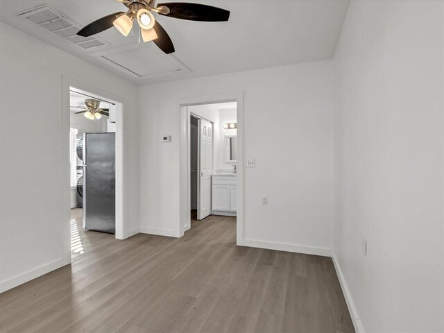 spare room with light wood-type flooring, ceiling fan, and sink