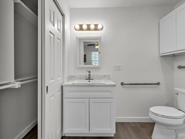 bathroom featuring hardwood / wood-style flooring, vanity, ceiling fan, and toilet