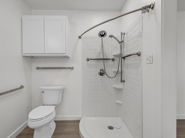 bathroom featuring toilet, wood-type flooring, and walk in shower