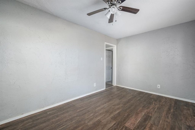 empty room with dark hardwood / wood-style flooring and ceiling fan