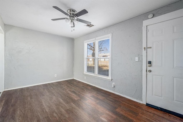 empty room with ceiling fan and dark wood-type flooring