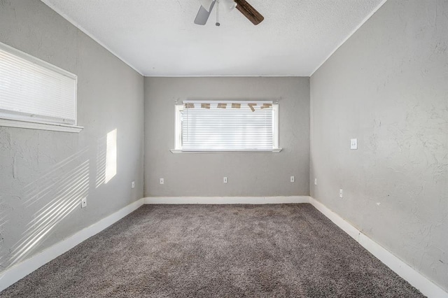 carpeted spare room featuring ceiling fan and a textured ceiling